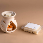 Load image into Gallery viewer, Ceramic wax melt burner with lit tealight and wax melts on beige background