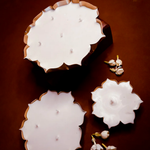 Load image into Gallery viewer, Lotus-shaped white candles with multiple wicks on brown background, jasmine flowers nearby.