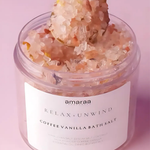 Load image into Gallery viewer, Open jar of amaraa Relax Unwind coffee vanilla bath salt with dried botanicals on pink background.