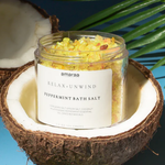 Load image into Gallery viewer, Jar of Amaraa Peppermint Bath Salt in opened coconut on blue background
