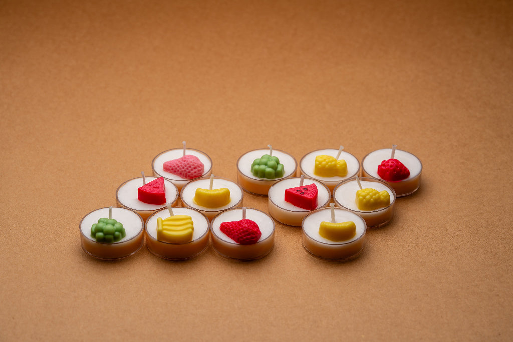 Fruit-shaped decorative tealight candles arranged on a brown surface