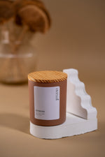 Load image into Gallery viewer, Amaraa soy wax candle with wood lid on white stand, modern beige background