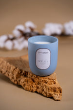 Load image into Gallery viewer, Amaraa natural soy wax candle in blue jar on cork with cotton flowers background