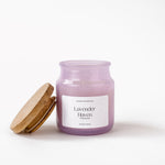 Load image into Gallery viewer, Lavender Haven purple scented candle in glass jar with wooden lid on white background