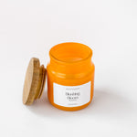 Load image into Gallery viewer, Orange Blushing Bloom scented candle with wooden lid on white background