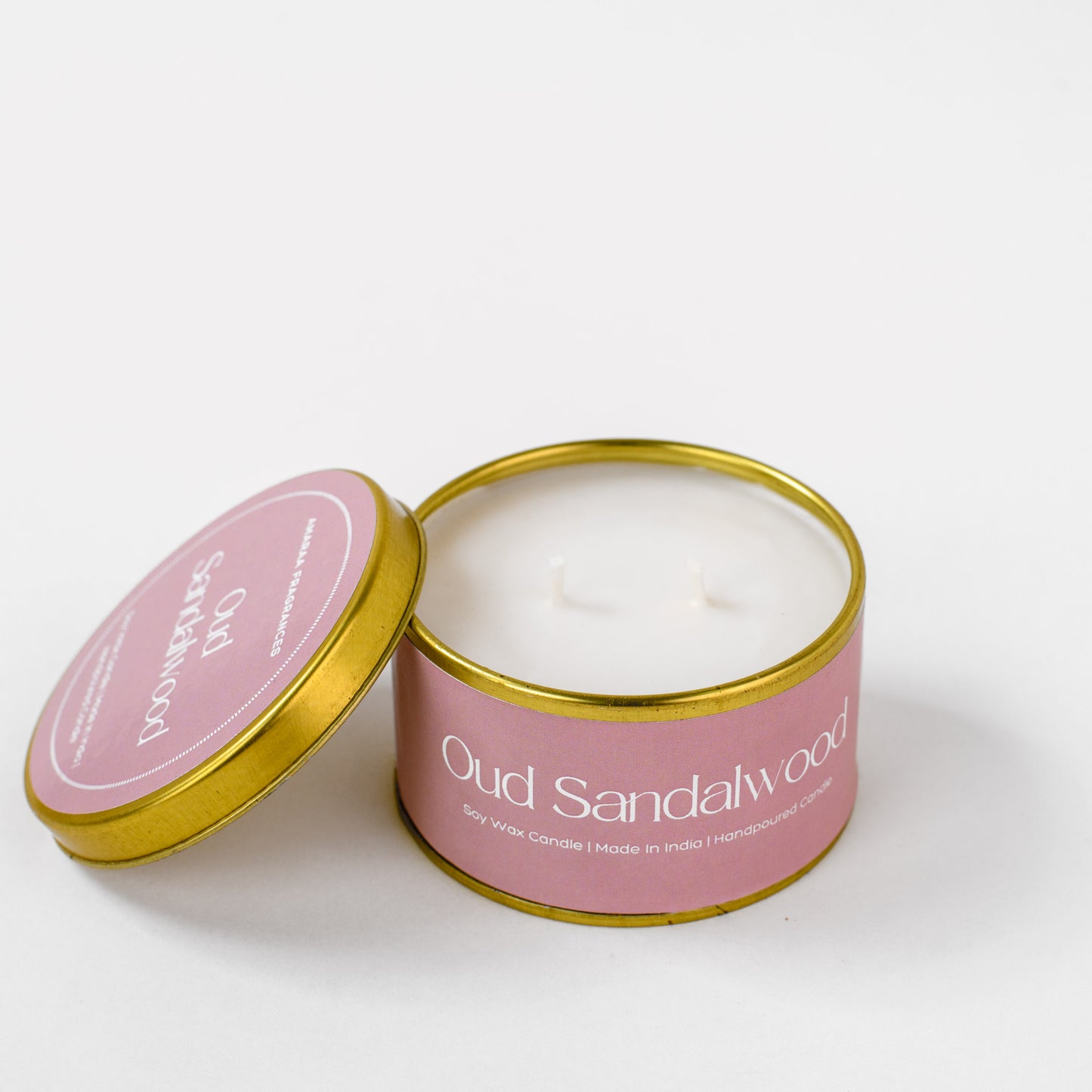 Oud Sandalwood soy wax candle in a pink and gold tin on white background