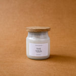 Load image into Gallery viewer, Musk Melody scented candle in glass jar with wooden lid on brown background