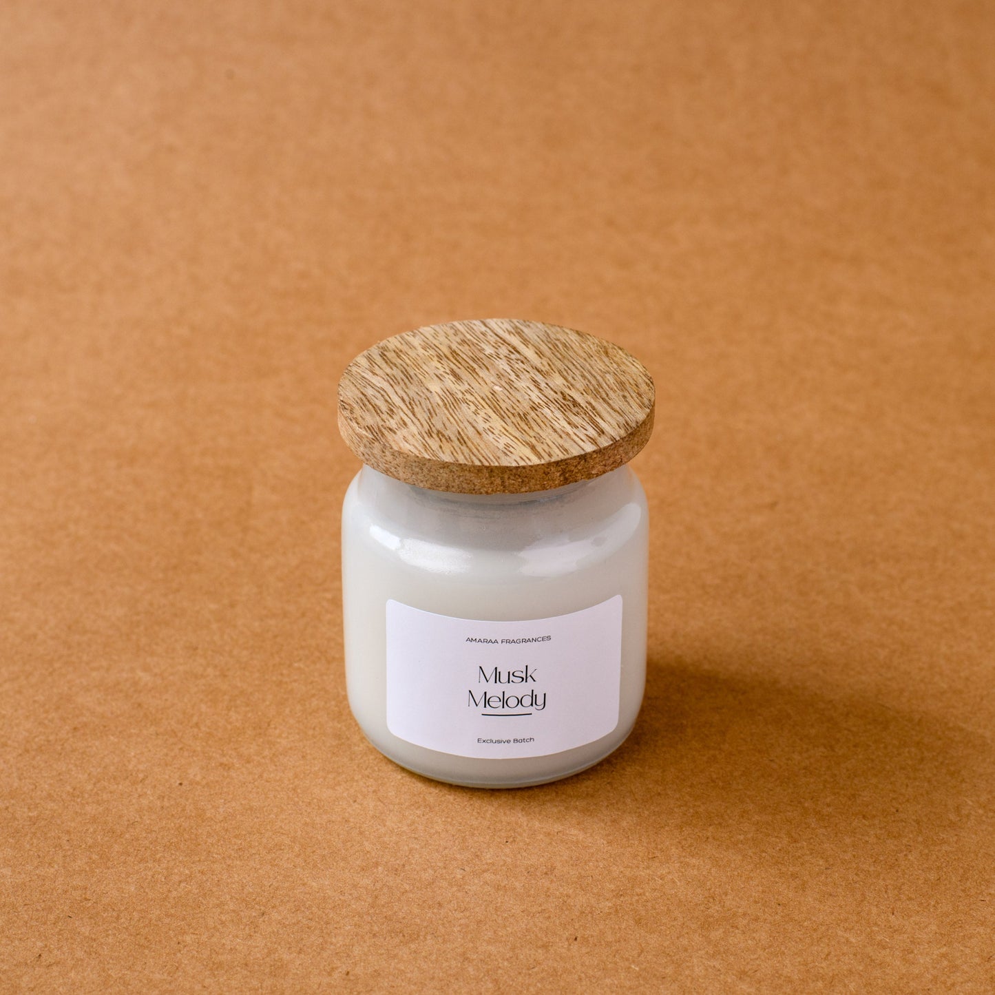 Musk Melody scented candle with wooden lid on brown background