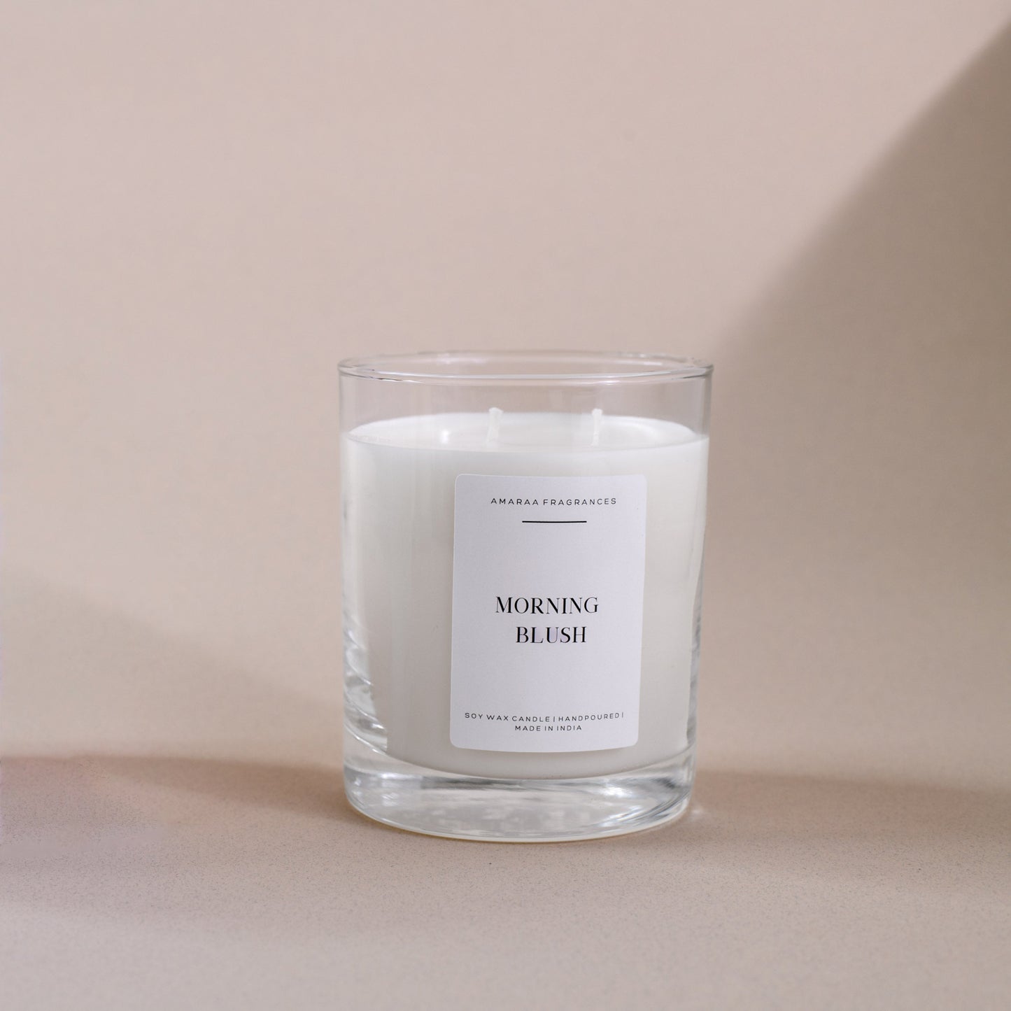 Morning Blush soy wax candle in clear glass jar on beige background, Amaraa Fragrances branding