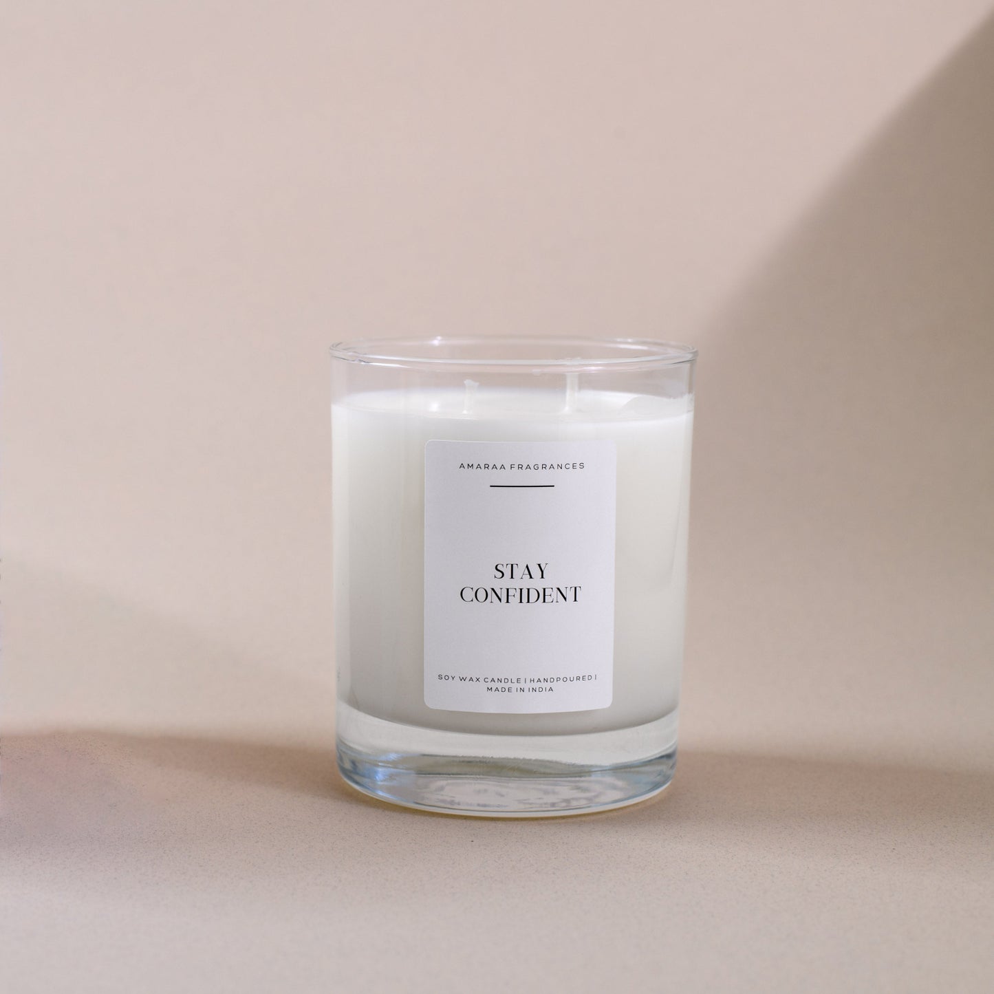 Handpoured Amaraa Fragrances Stay Confident soy wax candle in glass jar on beige background
