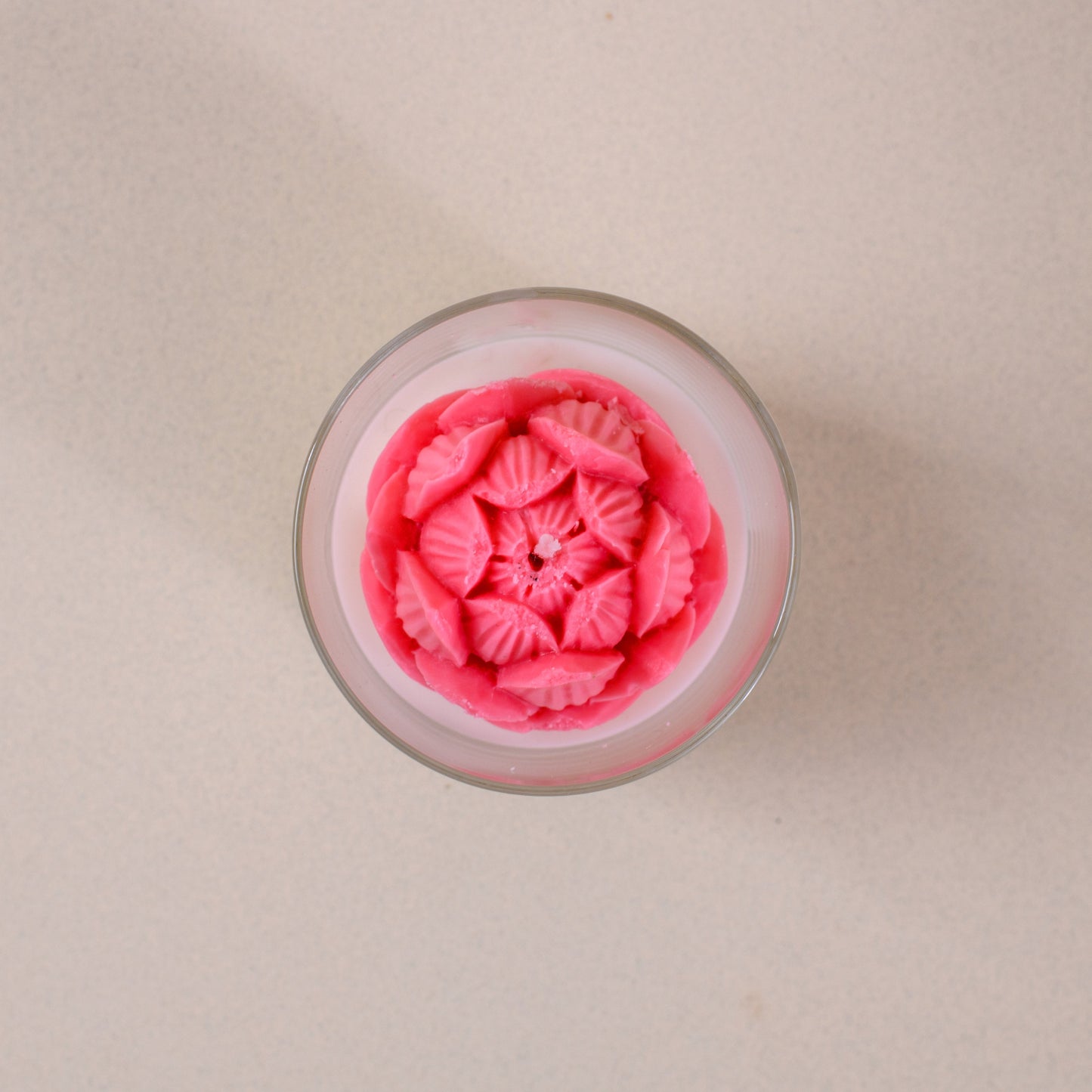 Pink flower-shaped Thai dessert in a glass on a light beige tabletop