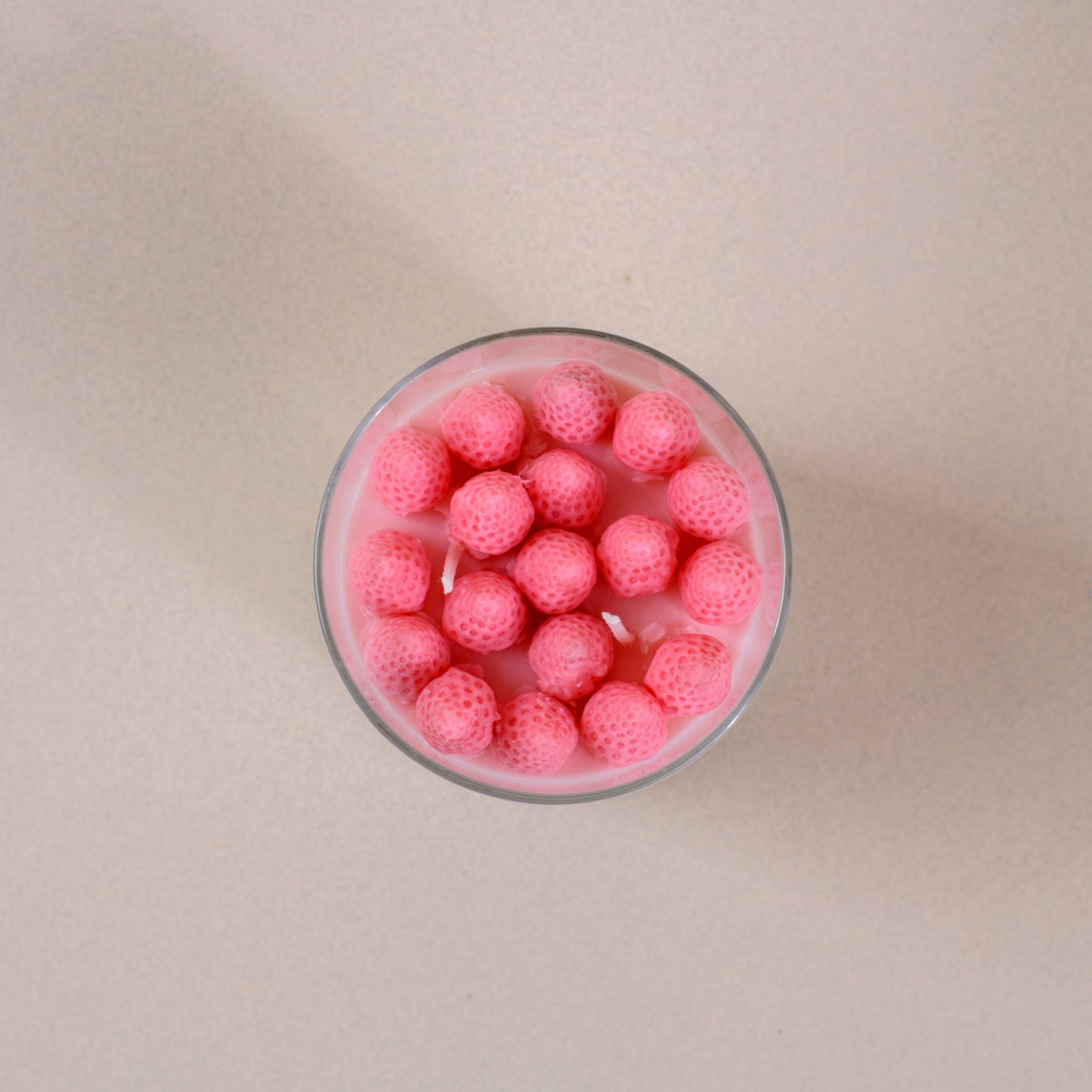 Glass of pink dessert with round tapioca balls on a light background