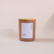 Brown jar amaraa soy wax candle with wood lid on neutral background