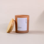 Load image into Gallery viewer, Brown soy wax candle labeled 'eternal amaraa' with wooden lid on beige background