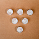 Load image into Gallery viewer, Six gemstone tealight candles with white wax on a brown surface, crystal decor