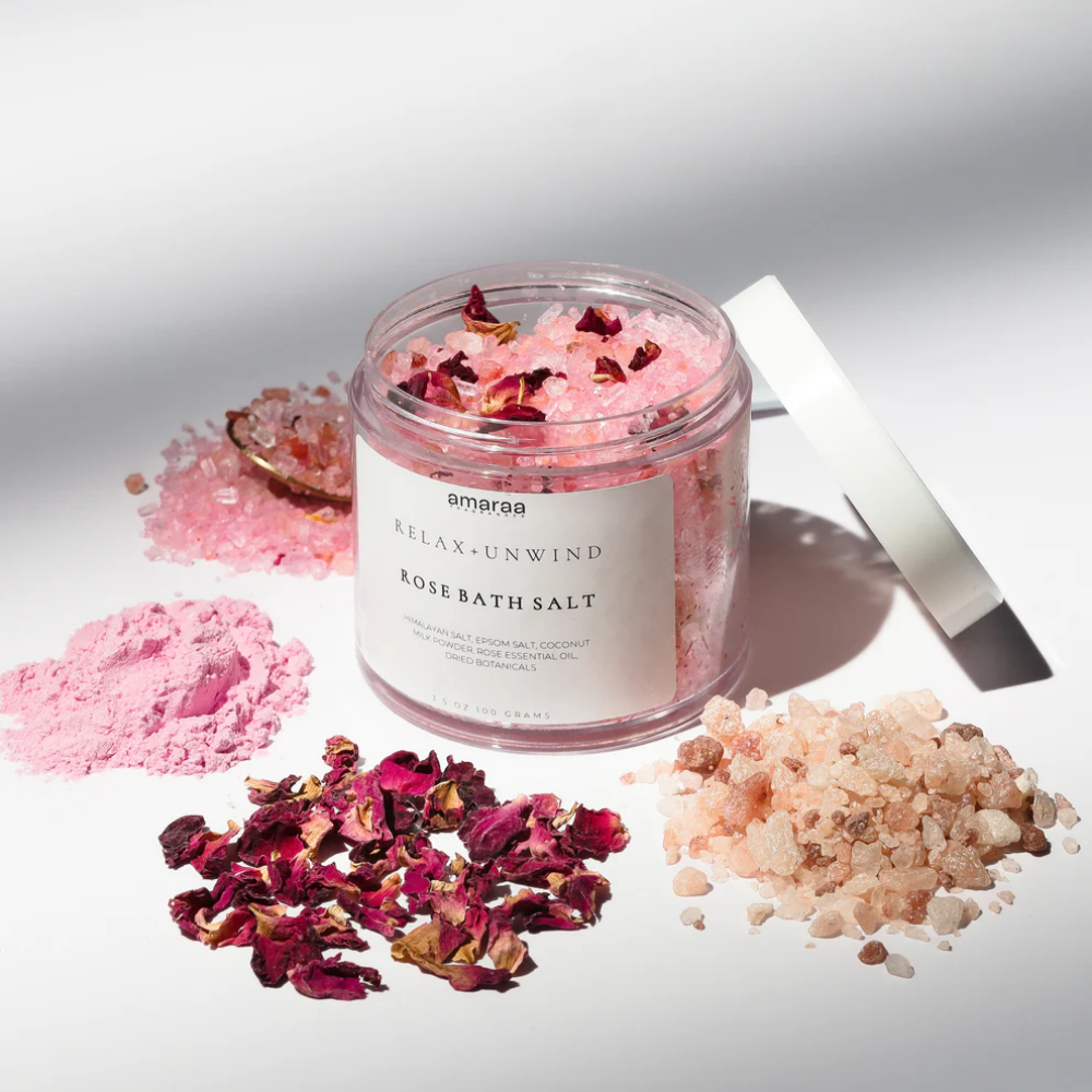 Open jar of Amaraa Relax + Unwind rose bath salt with pink crystals and dried rose petals