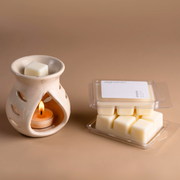 Ceramic wax melt burner with tealight and vanilla wax melts on beige background