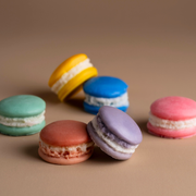 Colorful macarons with cream filling on a neutral background, assorted pastel cookies