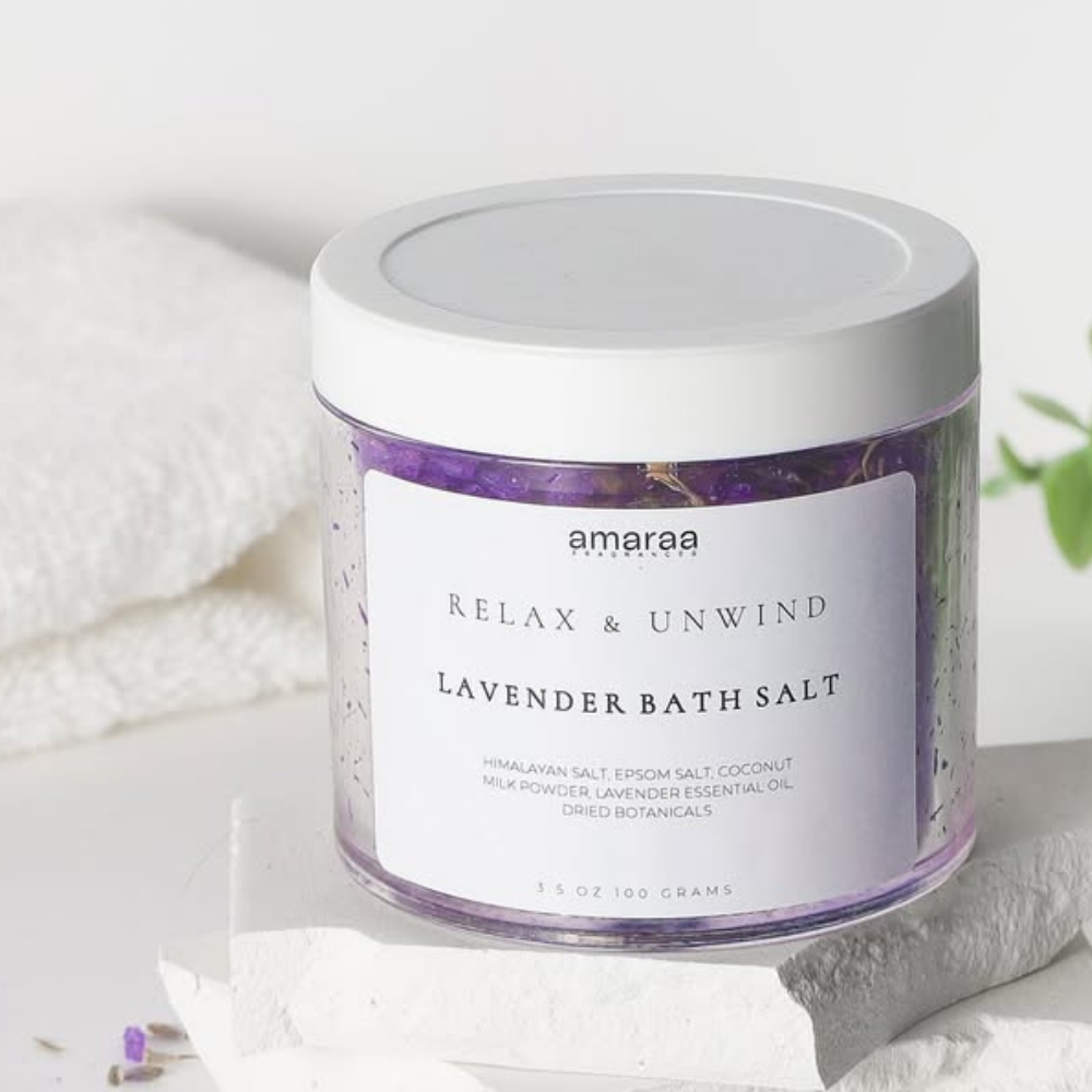 Amaraa lavender bath salt jar on white stone with towels and plant, relaxing spa product