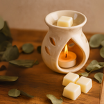 Load image into Gallery viewer, Ceramic wax melt warmer with tea light, wax cubes, and eucalyptus leaves on wood table