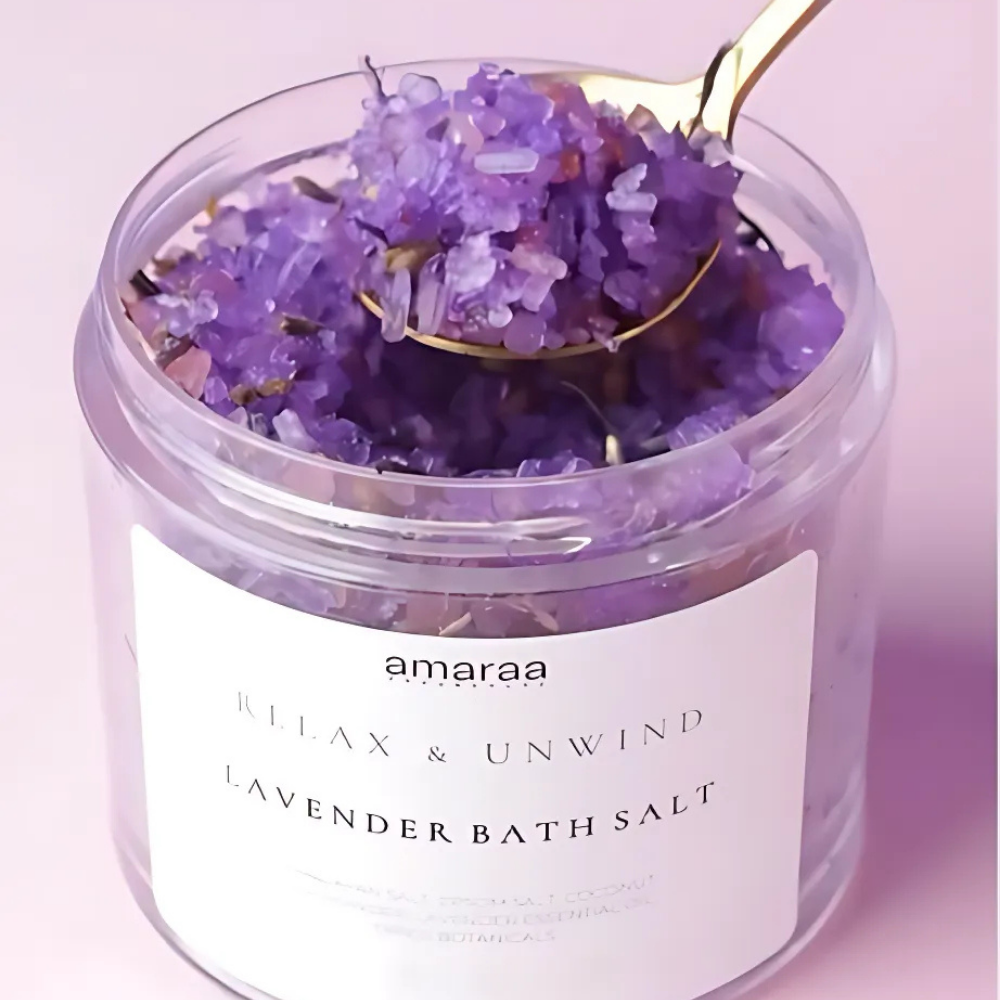 Lavender bath salt in clear jar with gold spoon, amaraa brand, on light pink background