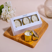 Amaraa tin scented candles gift set on wooden board with white roses and glass vase