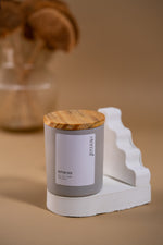 Load image into Gallery viewer, Eternal Amaraa soy wax candle with wooden lid on white sculptural stand, beige background