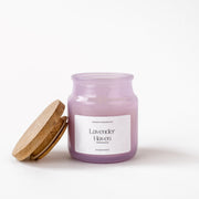 Lavender Haven purple scented candle in glass jar with wooden lid on white background