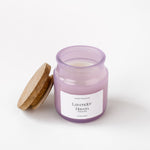 Load image into Gallery viewer, Lavender Haven scented candle in a frosted purple glass jar with wooden lid on white background