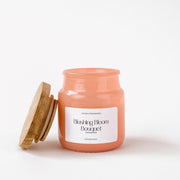 Blushing Bloom Bouquet scented candle jar with wooden lid on white background