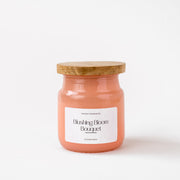 Blushing Bloom Bouquet pink scented candle jar with wooden lid on white background