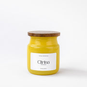 Yellow Citrina scented candle jar with wooden lid on white background