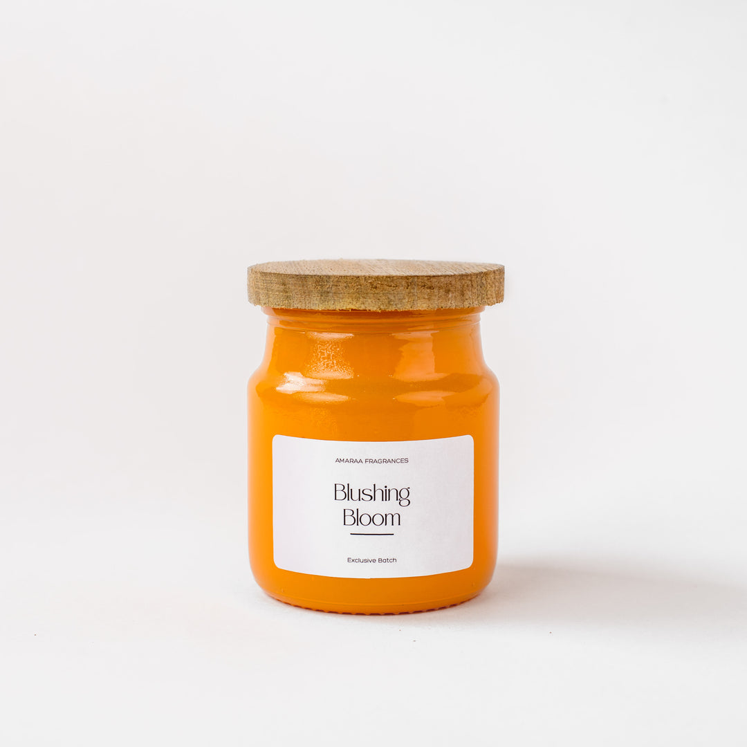 Orange Blushing Bloom scented candle jar with wooden lid on white background