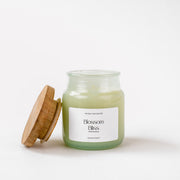 Glass jar Blossom Bliss scented candle with wood lid on white background