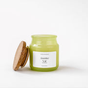 Jasmine Noir scented candle in green glass jar with wooden lid, white background