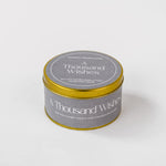 Load image into Gallery viewer, A Thousand Wishes soy wax candle in a round gold tin by Amaraa Fragrances on white background.