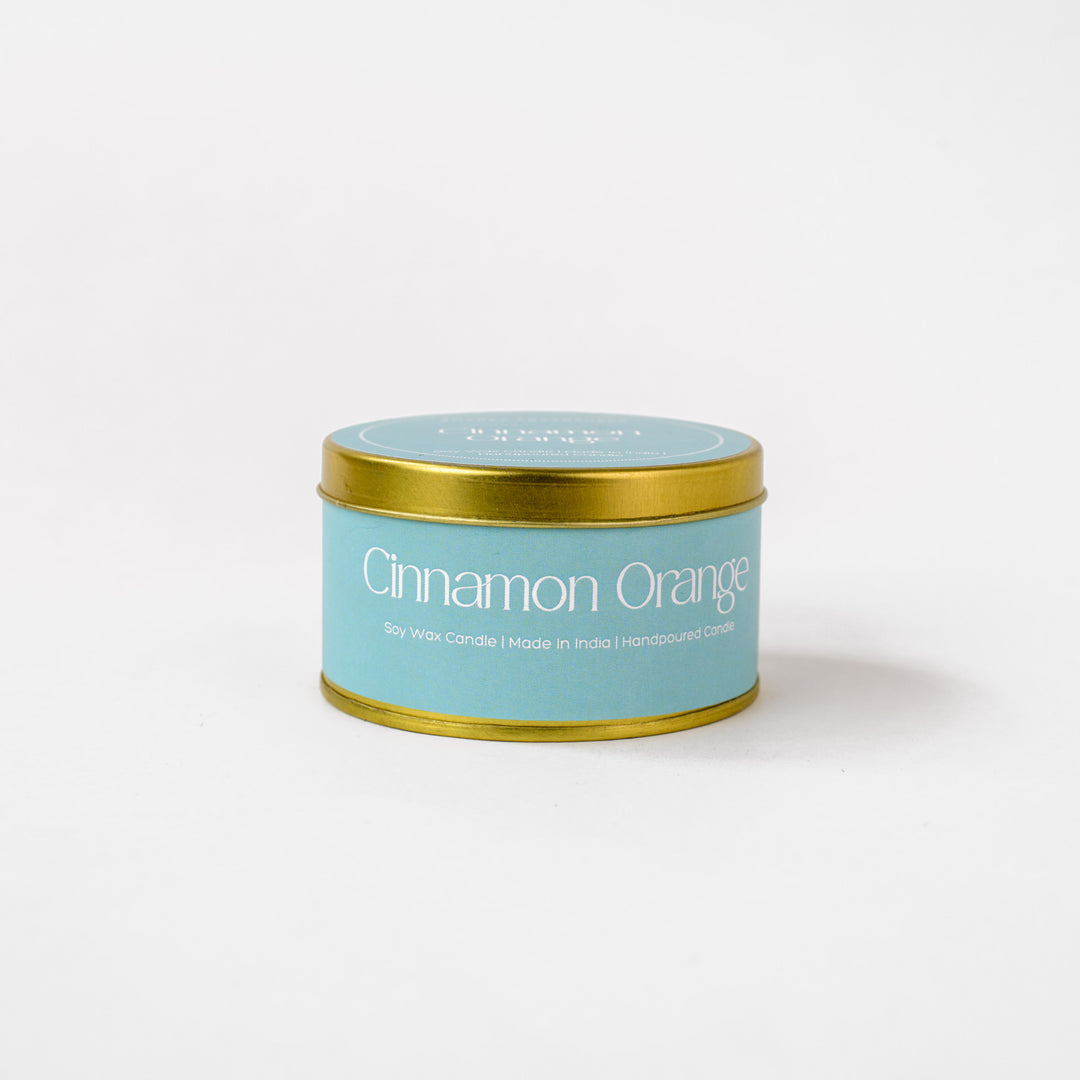 Cinnamon Orange soy wax candle in a blue tin with gold lid on white background