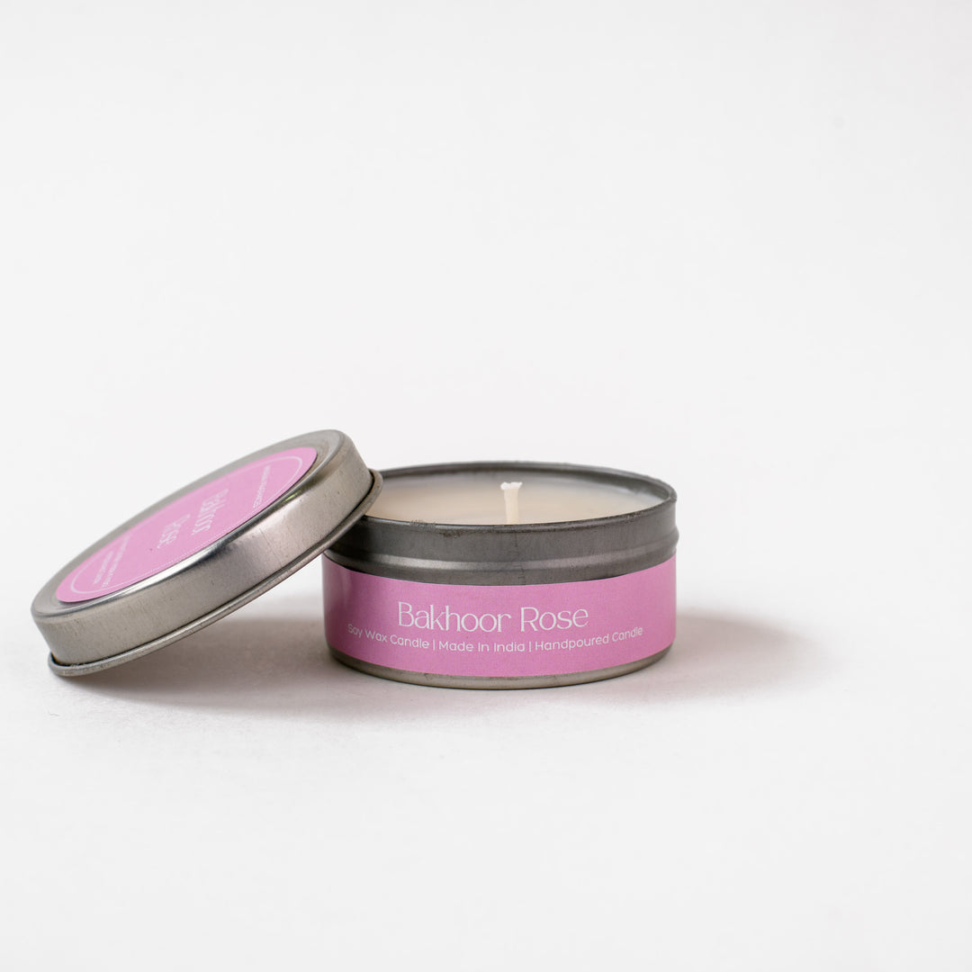 Bakhoor Rose soy wax candle in a metal tin with open lid on white background
