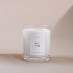 Load image into Gallery viewer, Amaraa Fragrances Love Story soy wax candle in clear glass on beige background