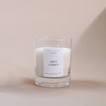 Load image into Gallery viewer, Amaraa Fragrances Misty Garden soy wax candle in clear glass jar on beige background