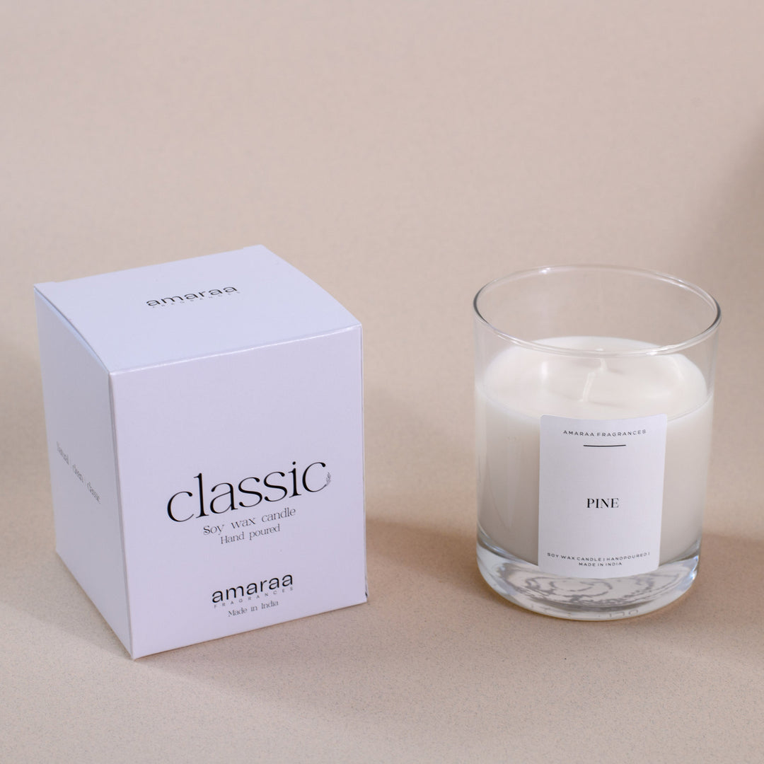 Amaraa classic pine soy wax candle with minimalist white packaging on beige background