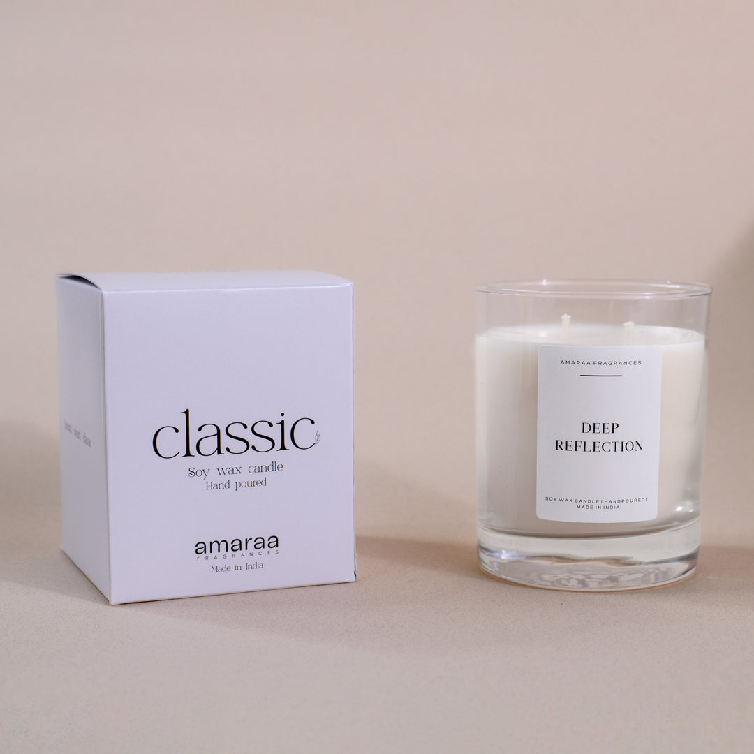 Classic soy wax candle in glass jar with Deep Reflection label and matching box on beige background