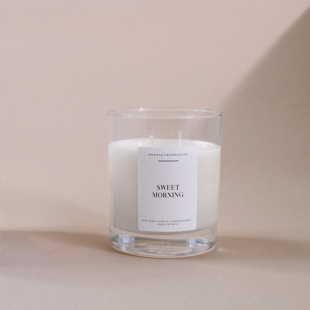 Amaraa Fragrances Sweet Morning soy wax candle in clear glass on beige background