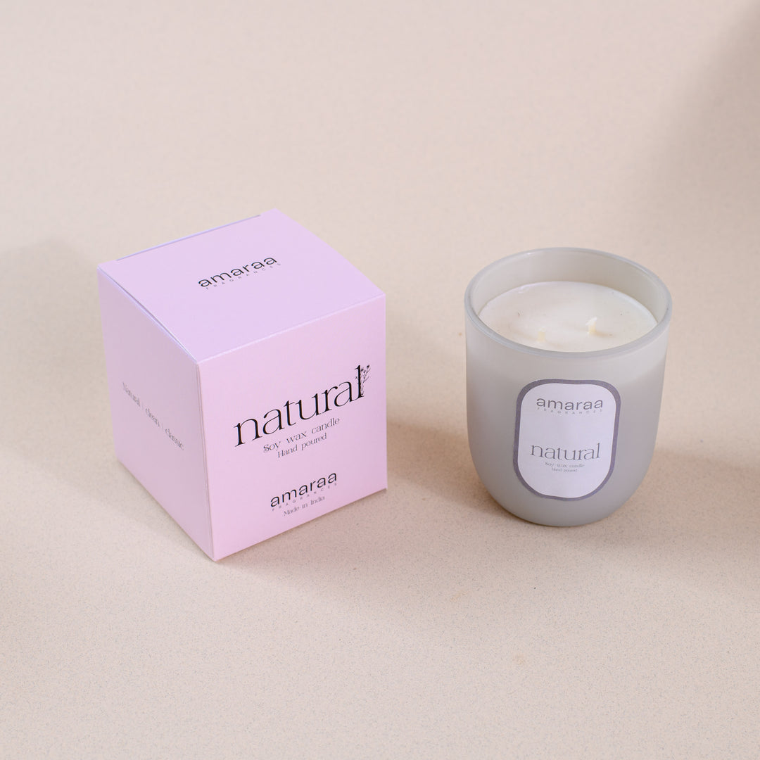 Amaraa natural soy wax candle in frosted glass with pink box on beige background
