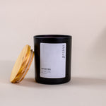 Load image into Gallery viewer, Black eternal amaraa soy wax candle with wooden lid on beige background
