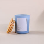 Load image into Gallery viewer, Blue soy wax candle in glass jar with wooden lid, labeled 'eternal amaraa', on neutral background