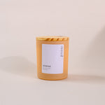 Load image into Gallery viewer, Amber glass soy wax candle with wood lid and 'eternal amaraa' label on beige background
