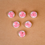 Load image into Gallery viewer, Six white tealight candles with pink heart shapes on brown background