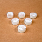 Load image into Gallery viewer, Six white tealight candles with crystals on brown background
