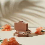 Load image into Gallery viewer, Natural handmade soap bars with peach flowers on a cream background, beauty product flat lay